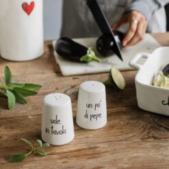 Set sale e pepe in ceramica con scritte “Sale in tavola” e “Metti un po’ di pepe”. Elegante, simpatico e perfetto per una tavola accogliente.
